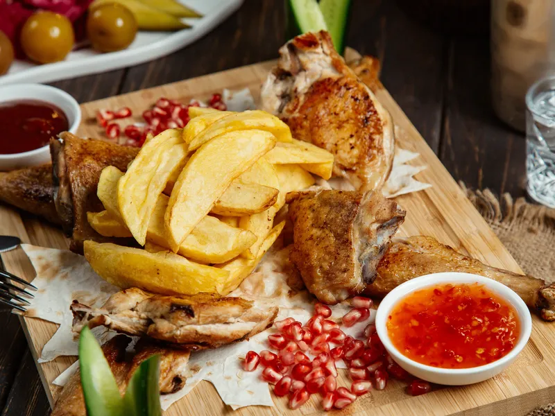 Pollo a la brasa, poulet rôti péruvien servi avec frites et sauces